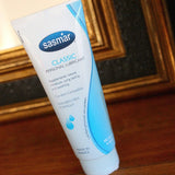 Tube of sasmar classic personal lubricant on a wooden surface with a mirror in the background